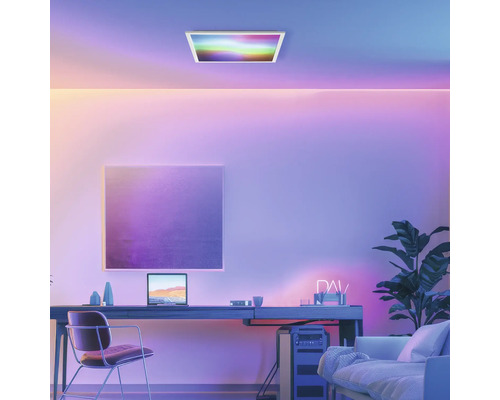 Kontorsrum med skrivbord, stol, krukväxt, taklampa och färgad belysning