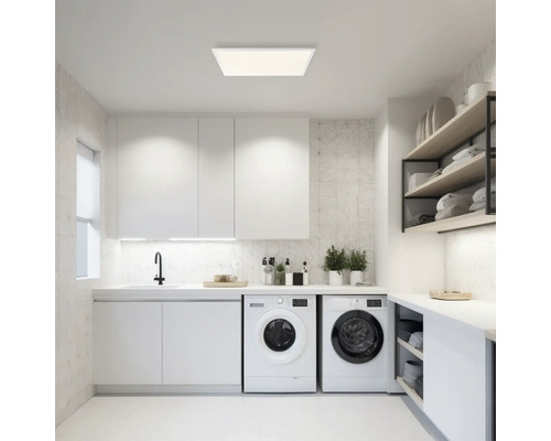 Ljust tvättrum med tvättmaskiner, diskho, skåp och hyllor