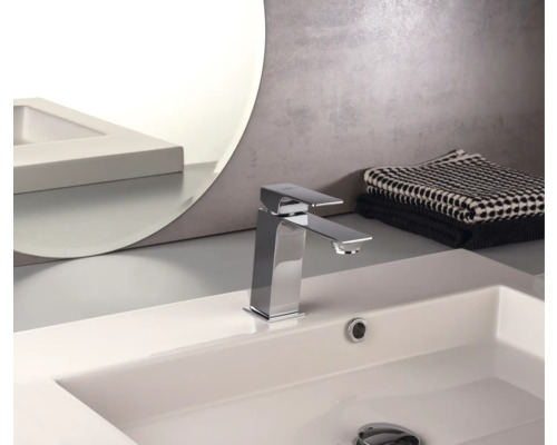 Tvättställsblandare av metall på ett tvättställ i badrummet