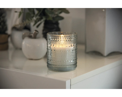 Dekorativt ljus i glas på ett vitt bord