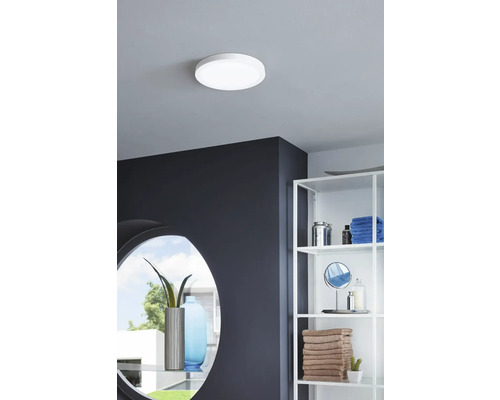 Taklampa i badrum med hyllor och spegel