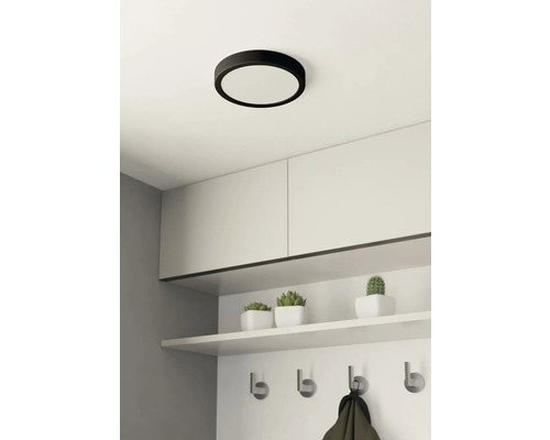 Rund taklampa ovanför garderob med krokar och förvaringsutrymme