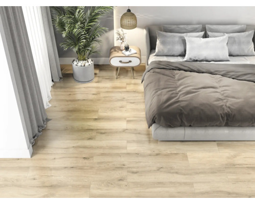 Sovrum med ljust trägolv, säng, sängbord och krukväxt