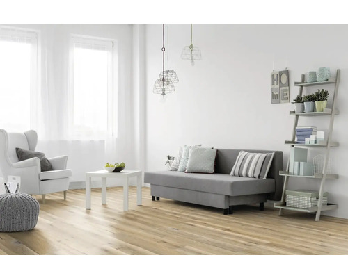 Ljust vardagsrum med soffa, fåtölj, bord och hylla