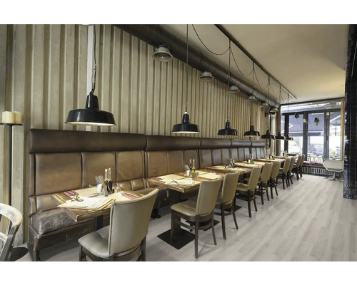 Interiörbild av en restaurang med bord, stolar, belysning och en sittbänk