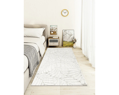 Sovrum med säng, sängbord och mönstrad matta