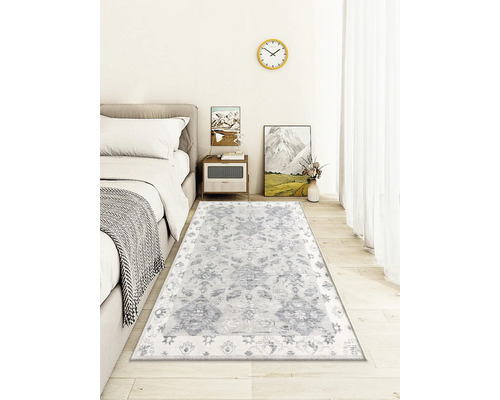 Dekorativt vardagsrum med en mönstrad matta under en säng.