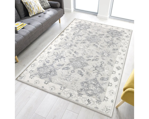 Matta med grått blommönster i ett vardagsrum med soffa