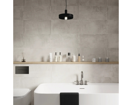 Modernt badrum med badkar, toalett, hylla och grå väggplattor