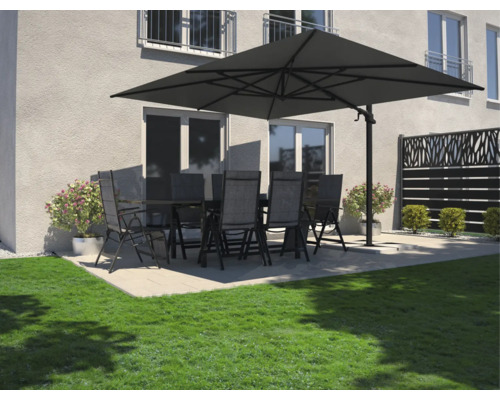 Trädgårdsmöbelset med bord, stolar och parasoll på en terrass