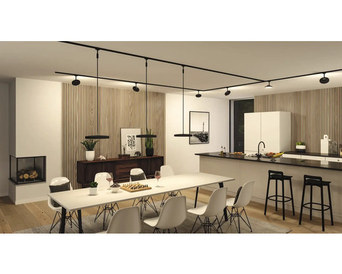 Vardagsrum med matbord, stolar, köksö och svart skensystem med lampor