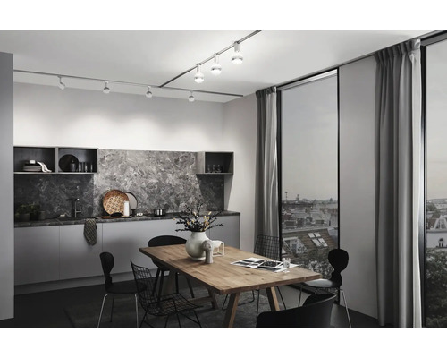 Modernt kök med matbord, stolar och skensystem med spotlights för belysning.