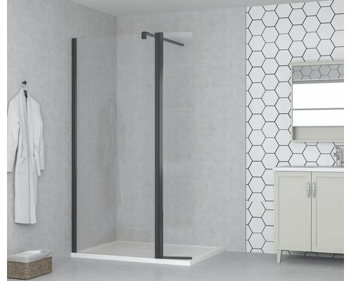 Badrum med duschkabin med svart ram, handfat och vit badrock