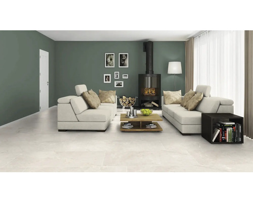 Vardagsrum med sittgrupp, kamin, soffbord och keramiska golvplattor.