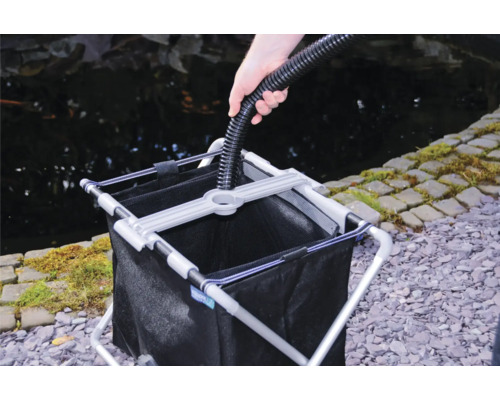 Dammsugare för damm med uppsamlingsbehållare i bruk bredvid en damm.