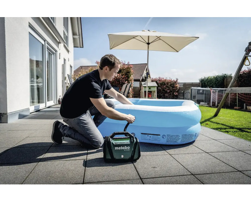Man pumpar upp en uppblåsbar pool på terrassen med en sladdlös Metabo-luftpump.
