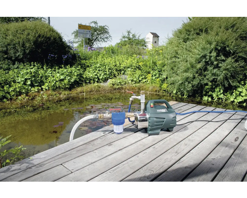 Metabo trädgårdspump på träbrygga vid en damm i trädgården