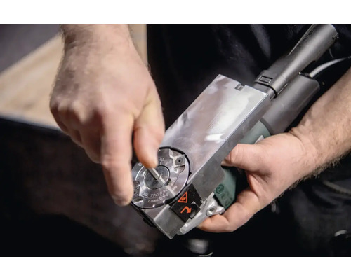 En person justerar en kantfräsmaskin.