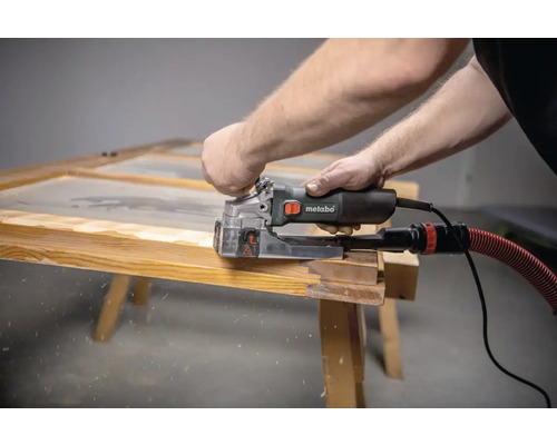 Man arbetar på en träram med en Metabo spårfräs.
