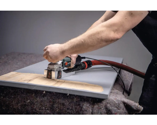 En person använder en spårfräs på ett arbetsstycke.