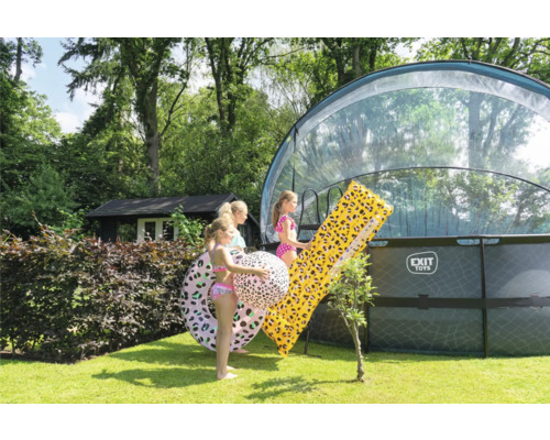 Tre barn med badringar och luftmadrass vid poolen i trädgården