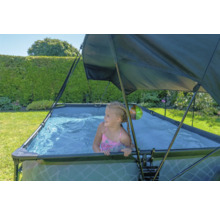 Flicka i en rektangulär pool med solskydd i trädgården