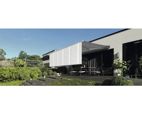 Terrass med markis och trädgårdsmöbler framför ett modernt hus