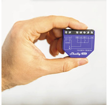 En hand håller en Shelly Gen3 smart home-switch.
