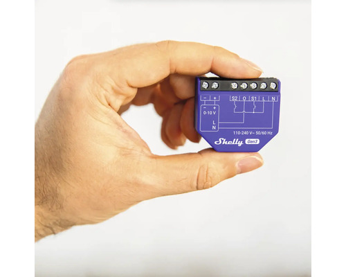En hand håller en Shelly Gen3 smart home-switch.