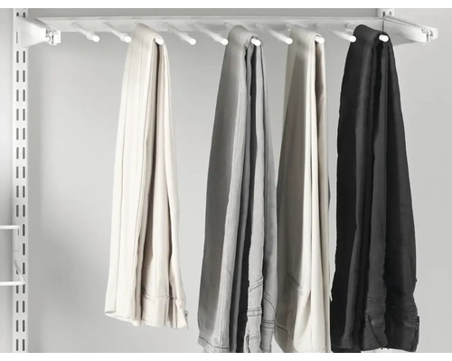 Byxhållare med flera byxor på ett vitt skensystem