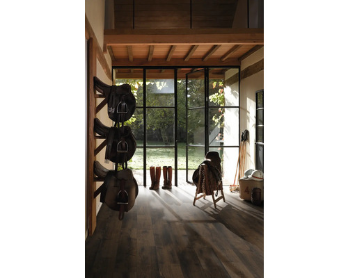 Hästsadel i stall med trägolv och dagsljus