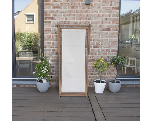 Träsolstol med textilklädsel utomhus, omgiven av krukväxter