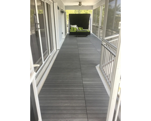 Veranda med trall av träkomposit och trädgårdsmöbler.