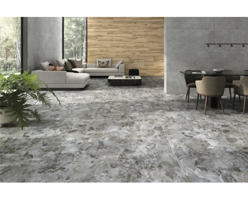 Interiör med golvplattor i stenimitation, soffa, matbord och växt