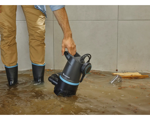 Man med Gardena smutsvattenpump i översvämmat rum.