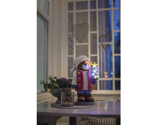 Dekorativ björnfigur med LED-julgran på ett bord i ett rum.