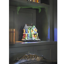 Dekorativt upplyst julhus på en hylla