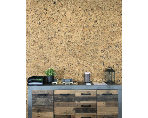 Väggdekoration med korktapet bakom en skänk med lådor och dekoration.