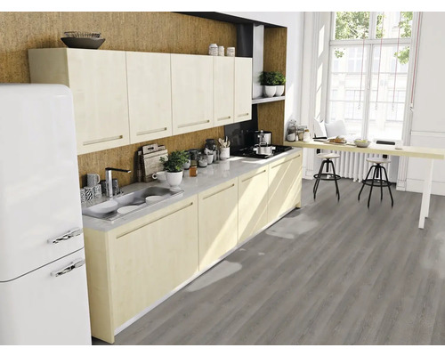 Modernt kök med inbyggda skåp, diskho, spishäll, köksbänk och barstolar i ett ljust rum.