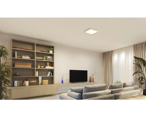 Vardagsrum med bokhylla, TV, soffa och fyrkantig taklampa