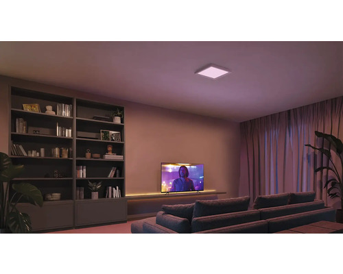 Vardagsrum med bokhylla, TV, soffa och fyrkantig taklampa