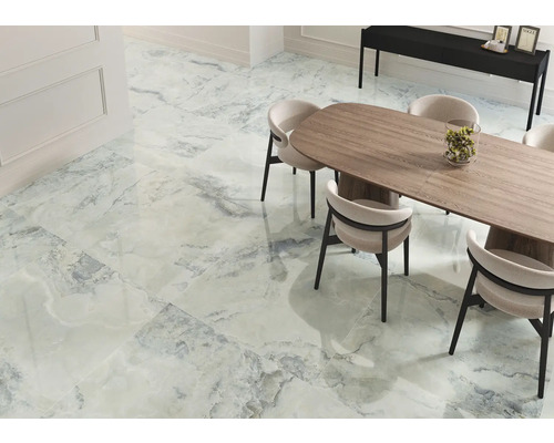 Ljust rum med plattor i marmorlook, matbord och stolar.