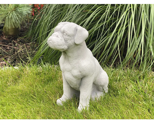 Dekorativ trädgårdsfigur av en sittande hund på en gräsmatta