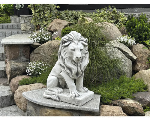 Lejonstaty av sten i trädgården