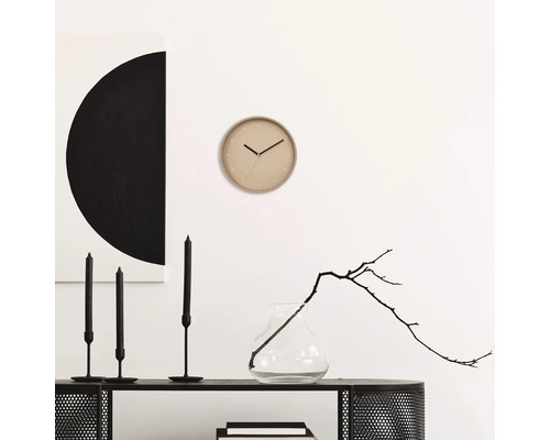 Vardagsrumsscen med väggklocka, ljus och dekoration på en hylla