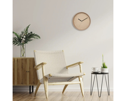 Vardagsrum med träskåp, fåtölj, bord och väggklocka