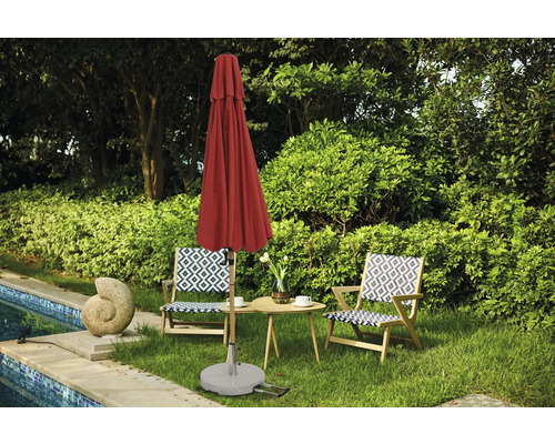 Trädgårdsscen med stängt parasoll, trädgårdsbord och två stolar