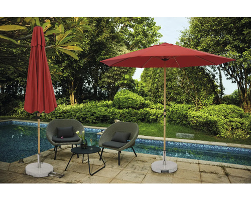 Scen med två trädgårdsstolar, ett litet bord, ett öppet och ett stängt parasoll bredvid en pool