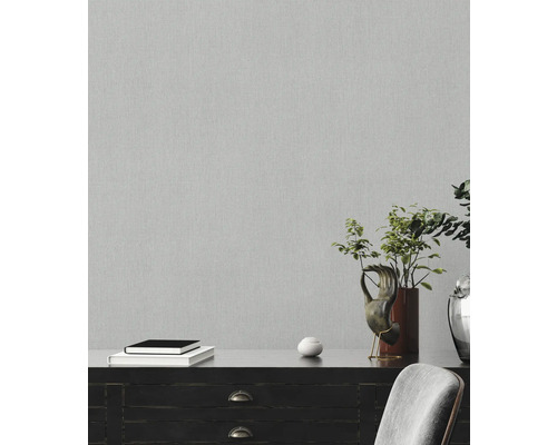 Närbild av en grå non-woven tapet med fin struktur på en vägg.