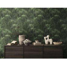 Närbild av en vägg med en tapet med bladmotiv som skapar en tropisk atmosfär